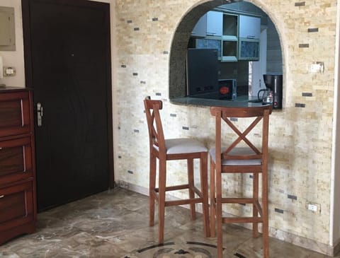Curved serving hatch provided with two bar stools
