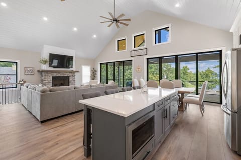 Open floor plan with kitchen, dining, and living area. Take in views from the glass doors/windows