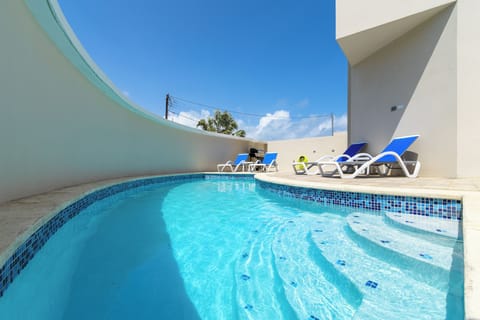 Refreshing Shared Pool Area of the 2-BR Condo in Noord Aruba - Relax by the shimmering poolside oasis - Dive into a refreshing poolside escape - Lounge in tranquility by the sparkling waters