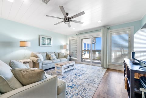 Unwind in your bright, coastal-inspired living room with plush seating and balcony access to enjoy refreshing breezes.