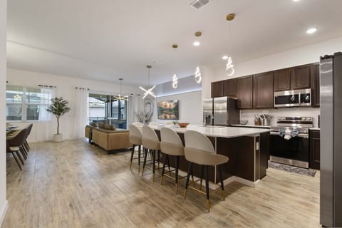 Modern open-concept kitchen with sleek finishes, stylish lighting, and spacious seating.