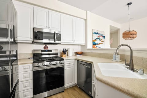 Stainless steel appliances w/white cabinetry and granite countertops