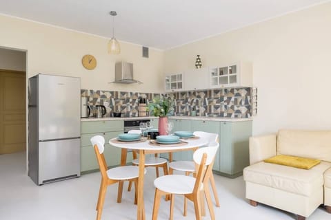 A wide-angle view of the kitchen and dining area, filled with natural light and vibrant colors.

