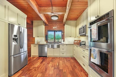 The kitchen is equipped with stainless steel appliances, including a double oven