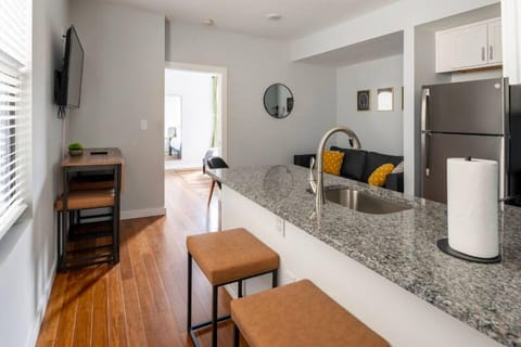 Entryway with room darkening wooden shades, dining seating at kitchen island.