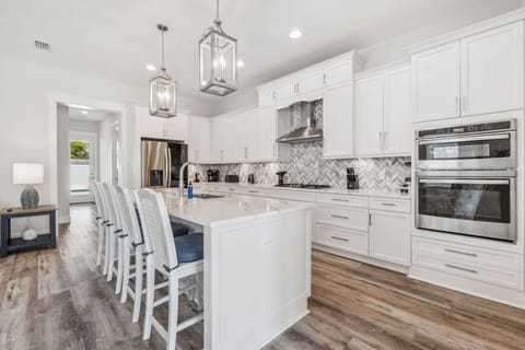 Fully-Stocked Kitchen with Tile Backsplash, Stainless Steel Appliances and Island Bar Seating