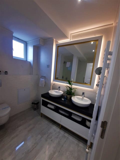 Deluxe Studio Suite | Bathroom | Shower, rainfall showerhead, hair dryer, slippers
