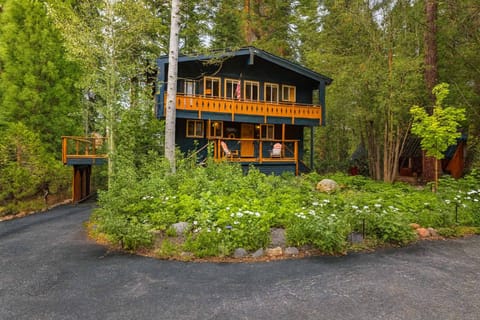 Charming forest chalet with rustic balconies and lush greenery—perfect for a peaceful mountain escape surrounded by nature.
