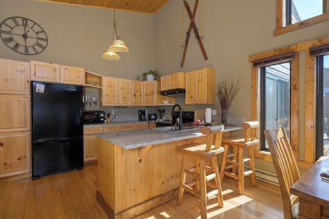 You'll love cooking in this warm, rustic kitchen with natural wood cabinets, granite counters, and cheerful morning light streaming through large windows.