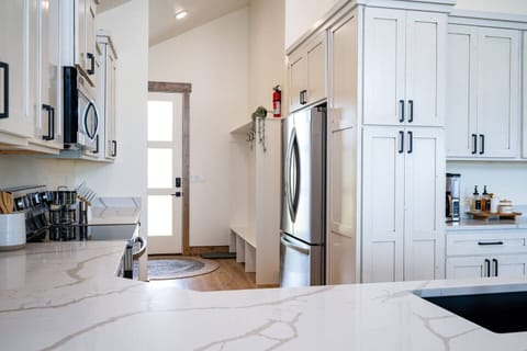 View of entry to the kitchen, with plenty of space for coats and shoes next the the refrigerator.