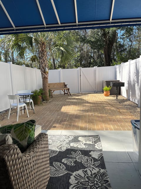 Backyard with covered porch and couch to relax on.  Bench turns into table.