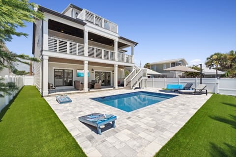 Private saltwater pool with lounge seating—perfect for relaxing after beach days, plus a fenced-in backyard & cornhole.