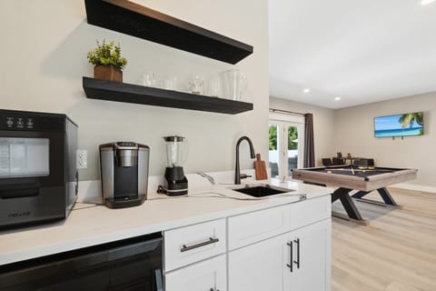 First-floor half kitchen / wet bar area — perfect for poolside snacks, drinks, and added entertaining space.