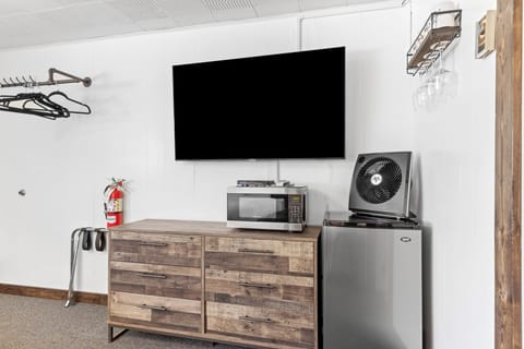 Main room with flat screen TV, large dresser, microwave, mini fridge and Keurig