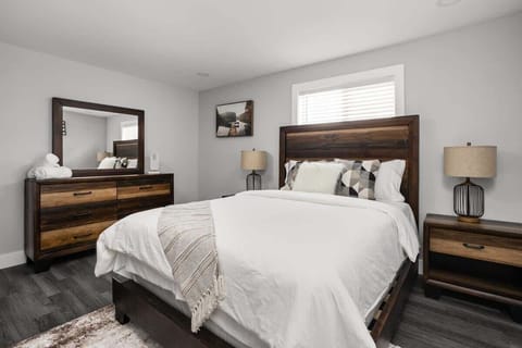Bedroom: Stylish room with a plush queen bed, sleek wooden furniture, and inviting natural light!