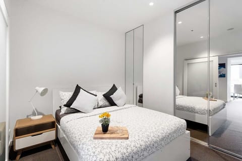 A bedroom with a queen sized bed & plush pillows.