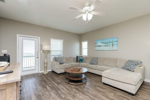 Unwind in your spacious living room featuring a plush sectional sofa and coastal artwork, where you'll create lasting vacation memories.