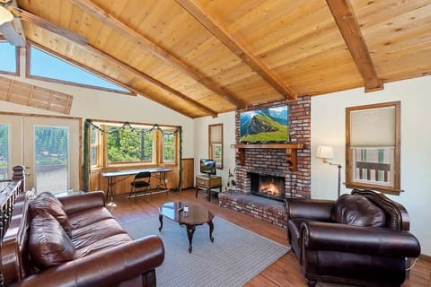 Relax in the living room with large sofa, lounge chair, smart TV, fireplace, and beautiful views 