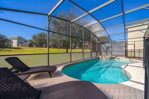 From your shaded lounge, gaze out at the expansive, crystal-clear pool, surrounded by a stylish screen for added privacy.