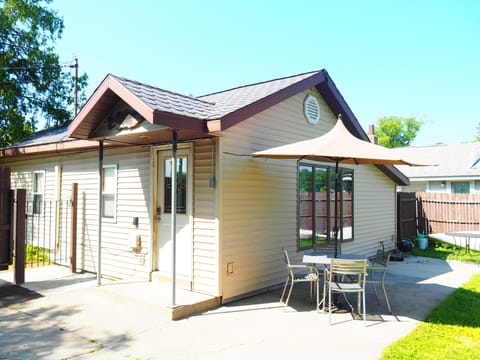 EXTERIOR: The side and back of the house in summer.