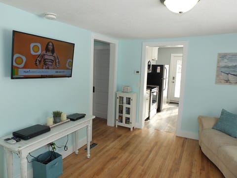 Downstairs Living Room:  Another view of the downstairs living room showing the doorway to the kitchen on the right and the doorway to the bathroom and stairwell on the left.