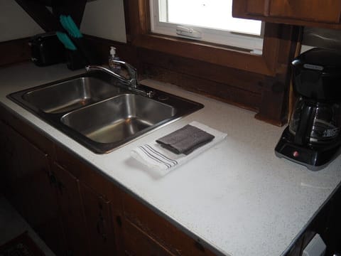 KITCHEN:  The cottage has a small kitchen with all appliances except for a dishwasher.  It does include a separate beverage cooler as well as a good supply of cooking and dining utensils.