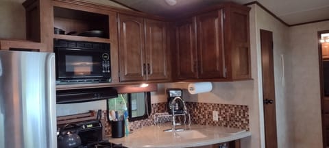 KITCHEN:  The home has a cute little kitchen with a refrigerator, sink, counter, stove, oven, and microwave.  There is also a collection of cooking and dining utensils provided.