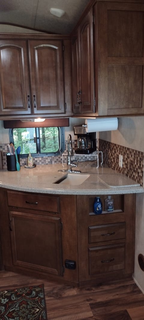 KITCHEN:  The home has a cute little kitchen with a refrigerator, sink, counter, stove, oven, and microwave.  There is also a collection of cooking and dining utensils provided.