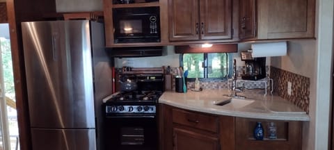 KITCHEN:  The home has a cute little kitchen with a refrigerator, sink, counter, stove, oven, and microwave.  There is also a collection of cooking and dining utensils provided.