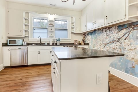 Spacious kitchen with a large island and two stools.