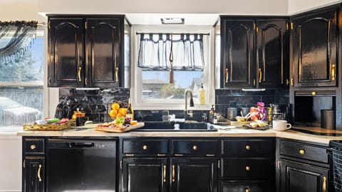 Spacious kitchen with bold black cabinets and natural light

