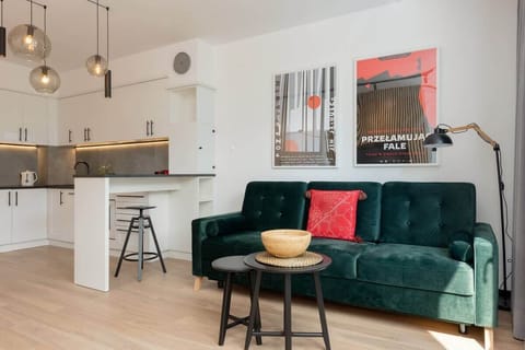 A stylish living area with a green velvet sofa, small coffee table, and modern wall art, creating a cozy ambiance.
