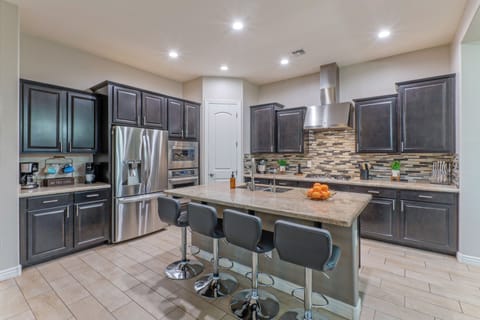 The modern, fully stocked kitchen has island seating for morning coffee and quick meals on the run.