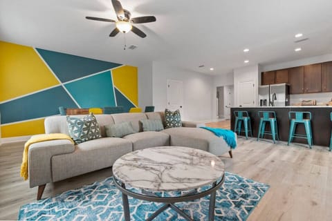 Open-plan living space with vibrant colors, and accent wall.