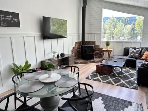 Dining room overlooking living room with TV, fireplace, and windows