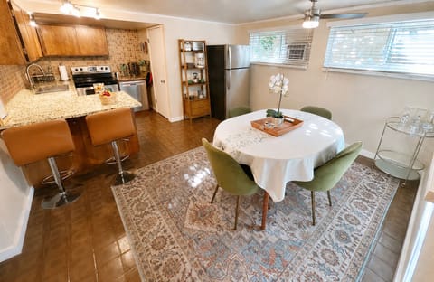 Bright open kitchen and dining area with granite counters and seating for 4