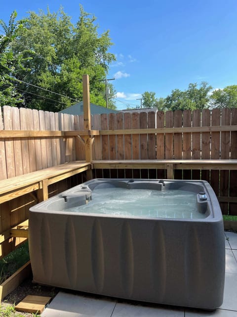 Hot tub with privacy fence just off the side of the house 