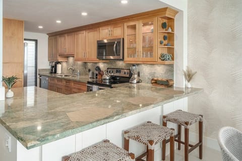 Cook and dine in style! This kitchen boasts gorgeous light green granite countertops and a comfy breakfast bar.