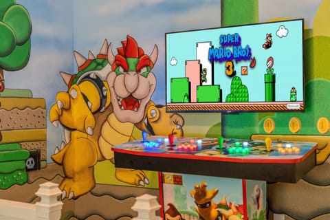 Join Mario, Luigi, Peach and the rest of the gang and take on Bowser in this amazing Mario themed room featuring a multi arcade with all the classic Mario games and more!