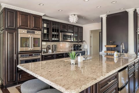 Built for efficiency and luxury, the kitchen features double microwaves, dual sinks, and both mini and full-sized fridges to cater to any culinary requirement.