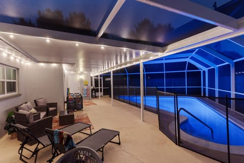 Beautiful blue lit pool w/ lighted, caged pool area
