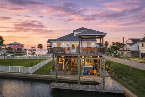 Stunning canal-front beach house in Galveston, TX with elevated deck, waterfront views, and private dock access—perfect for a luxury coastal getaway.