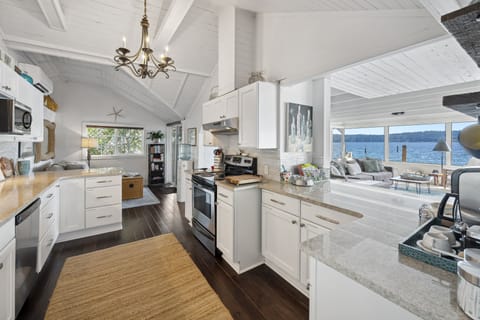 Step into a modern culinary masterpiece, where the pure elegance of white takes center stage in a beautifully designed kitchen.