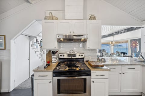 Prepare a gourmet meal or simply enjoy a morning cup of coffee, this modern white kitchen is a symphony of form and function, where simplicity meets sophistication, making every culinary endeavor a delightful experience.