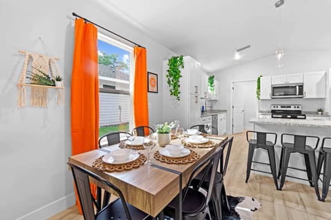 Cozy dining nook filled with natural light and vibrant orange accents.