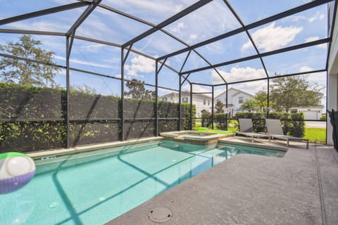 Step outside to your private oasis, featuring a glistening pool surrounded by a sleek, textured patio. The screened enclosure allows for sun-soaked relaxation while providing a tranquil view of lush greenery on all sides.
