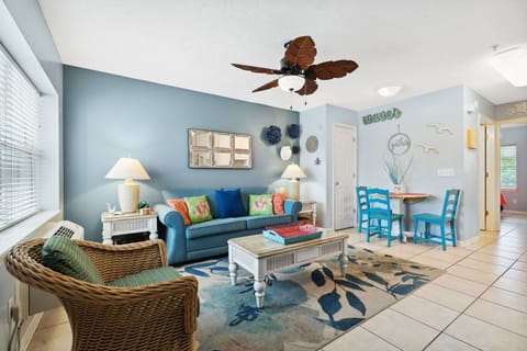 Cozy living area with coastal decor and a dining nook for four.