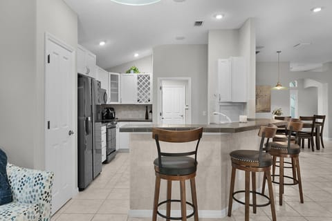 Your spacious kitchen features modern appliances, granite countertops, and comfortable bar seating perfect for morning coffee or casual meals together.