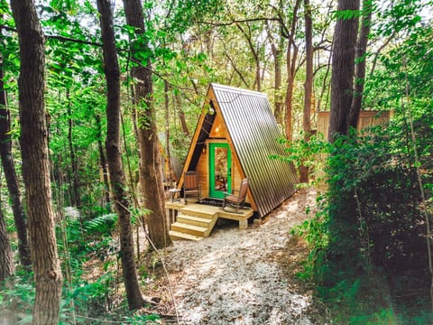 Tucked among leafy trees, this tiny A-frame cabin sets the scene for a quiet romantic forest retreat