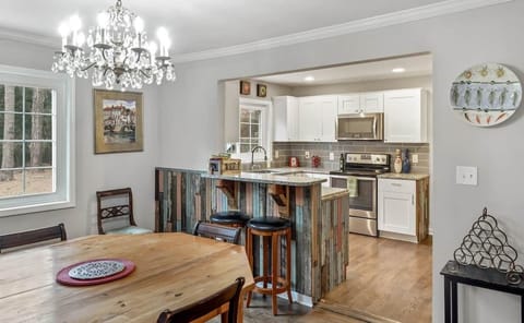 Dining room is large and roomy and open to the kitchen. It has a custom octagonal table made from vintage heart of pine. The legs are Victorian porch posts.   The crystal chandelier is 1930s and German.
